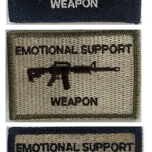 May include: Three embroidered patches with the text "EMOTIONAL SUPPORT WEAPON" and a rifle graphic. The patches are black, olive green, and tan with white or black text and graphics.