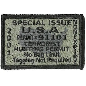 May include: A rectangular embroidered patch with a black border and olive green background. It features a map of the U.S.A. and text reading: SPECIAL ISSUE, U.S.A., PERMIT 91101, TERRORIST HUNTING PERMIT, No Bag Limit, Tagging Not Required, 2001, NONEXPIRY.