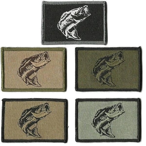 May include: Rectangular embroidered patches featuring a leaping bass fish design. The patches come in various colors, including black, olive green, tan, and gray. The fish is depicted with its mouth open, and the patches have a stitched border.