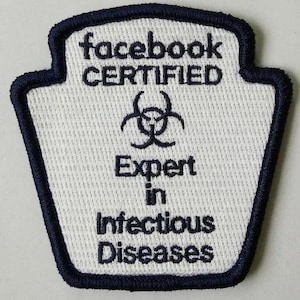 May include: A white patch with a navy blue border, featuring the text "facebook CERTIFIED" above a biohazard symbol and the words "Expert in Infectious Diseases."