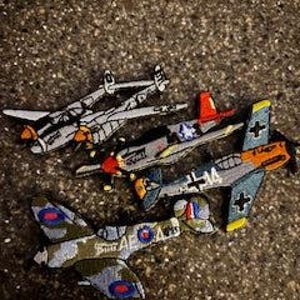 May include: A set of three ceramic mugs with a speckled, matte finish. The mugs are in shades of cream, light gray, and dark gray. Each mug has a simple, minimalist design and a rounded handle. Perfect for coffee or tea.