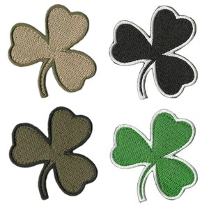 May include: Four embroidered shamrock patches in different colors: tan, black, olive green, and green with white trim. Each patch features a three-leaf clover design, perfect for St. Patrick's Day or Irish-themed crafts.