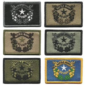 May include: A collection of rectangular embroidered patches featuring the Nevada state flag design. Each patch displays the words "BATTLE BORN" and "NEVADA" with a star and wreath. The patches come in various color schemes, including black, tan, green, and blue.