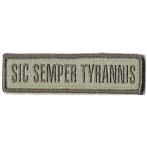 May include: A rectangular embroidered patch in shades of olive green and tan. The patch features the text SIC SEMPER TYRANNIS stitched in a dark olive thread against a lighter tan background, with a dark olive border surrounding the entire edge.