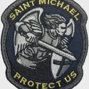 May include: Embroidered patch featuring Saint Michael, an angel with a sword and shield. The patch has a dark blue and gray color scheme with the words "SAINT MICHAEL" and "PROTECT US" in gold lettering. The patch is circular with a textured border.
