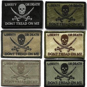 May include: A collection of six rectangular embroidered patches in various shades of black, olive, tan, and brown. Each patch features a central skull and crossbones design with the text LIBERTY OR DEATH above and DONT TREAD ON ME below.