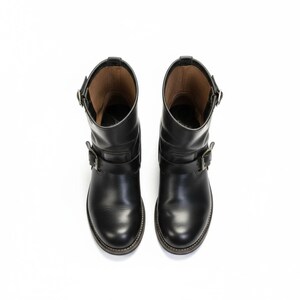 May include: A pair of black leather ankle boots with buckle fastenings. The boots have a rounded toe and a low heel. The boots are shown from a top-down perspective against a white background.