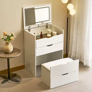 May include: A white vanity with a built-in mirror, two drawers, and a matching bench. The vanity has a lift-up mirror with a light. The drawers have black handles. The bench has a cushioned top. The vanity is in a well-lit room.