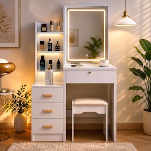 May include: A white vanity with a lighted mirror, three drawers, and a small stool. The vanity has a built-in shelf with various beauty products. The mirror is framed with a warm, glowing light. A cup and saucer sit on the vanity top.