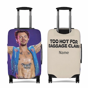 May include: A rolling suitcase with a picture of a person in a blue sequined vest. The other side of the case has the text "TOO HOT FOR BAGGAGE CLAIM" and a space for a name. It has a black handle and wheels. The case is designed for travel.