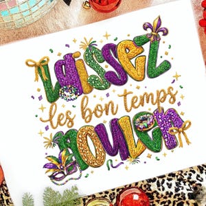 May include: A white card with the phrase "Laissez les bon temps rouler" in gold, purple, green, and yellow. The design includes a fleur-de-lis, a mask, and confetti, evoking a festive Mardi Gras theme.