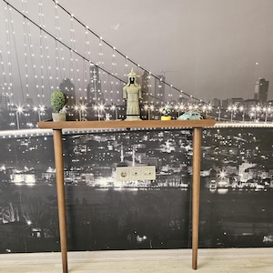This minimalist wooden console adds warmth and natural beauty to any hallway, living room, or entryway. Each piece is handcrafted from solid beech wood, sanded and stained by hand to achieve a smooth, durable walnut finish.