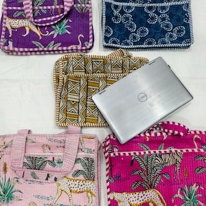 May include: A collection of quilted fabric laptop bags with various patterns. Designs include a purple bag with a leopard, a blue bag with a floral pattern, a pink bag with a leopard and flamingo, and a yellow and brown geometric pattern bag.