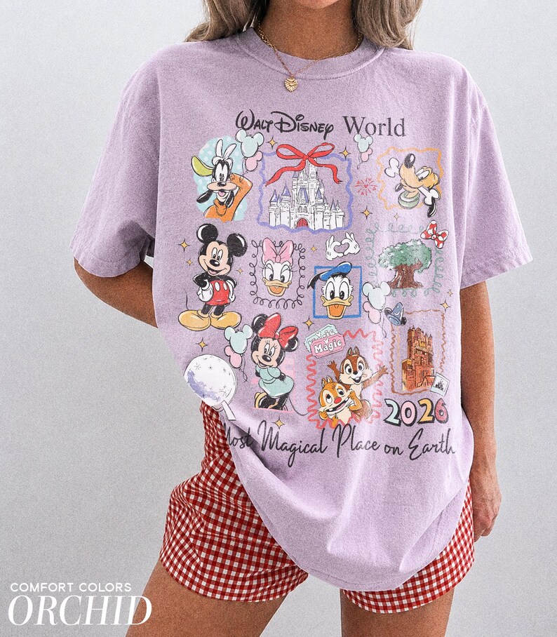 May include: A light purple t-shirt with a Walt Disney World graphic featuring Mickey Mouse, Minnie Mouse, Donald Duck, and other characters. The shirt also has the text "Most Magical Place on Earth" and "2026".