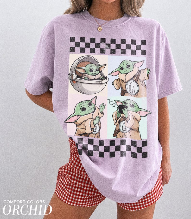 Puede incluir: Una camiseta de color lila claro con un dise&ntilde;o de Grogu de The Mandalorian en cuatro poses diferentes. El dise&ntilde;o incluye un patr&oacute;n de tablero de ajedrez en blanco y negro. La camiseta es Comfort Colors Orchid. La modelo lleva unos shorts a cuadros rojos y blancos.