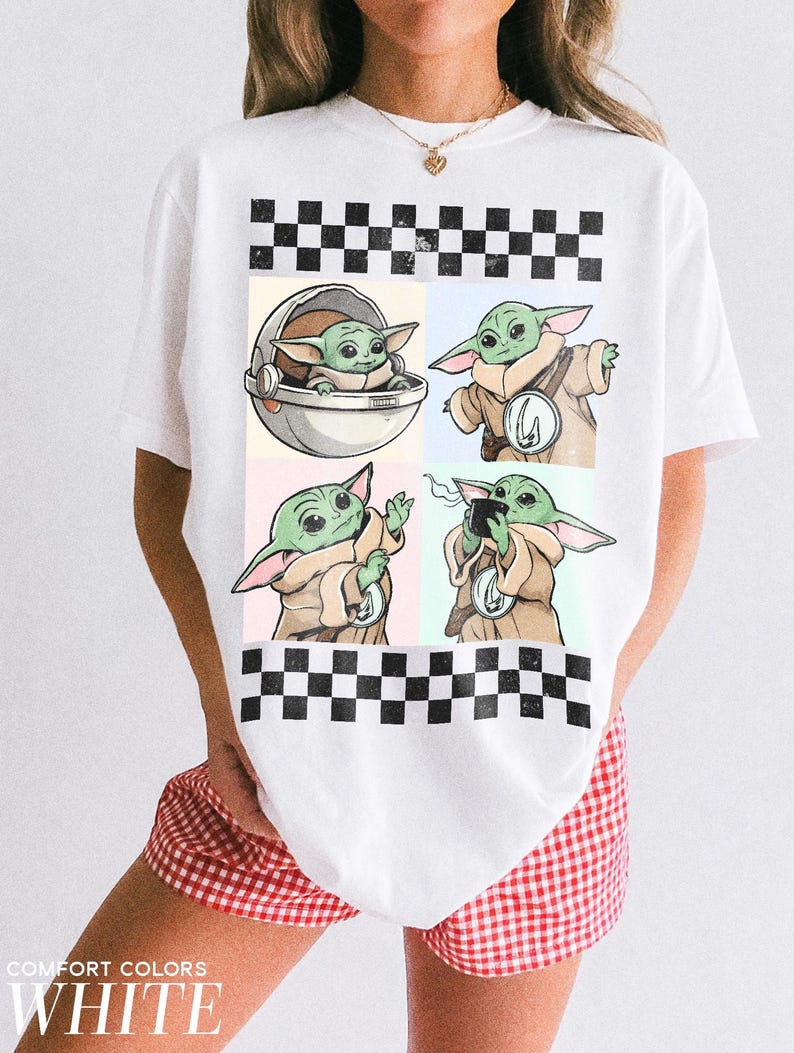 Puede incluir: Camiseta blanca con un dise&ntilde;o de cuatro paneles que muestra ilustraciones de un personaje alien&iacute;gena verde en varias poses. El dise&ntilde;o est&aacute; sobre fondos pastel y enmarcado por un patr&oacute;n de cuadros blanco y negro. El texto "COMFORT COLORS WHITE" est&aacute; impreso en la parte inferior.