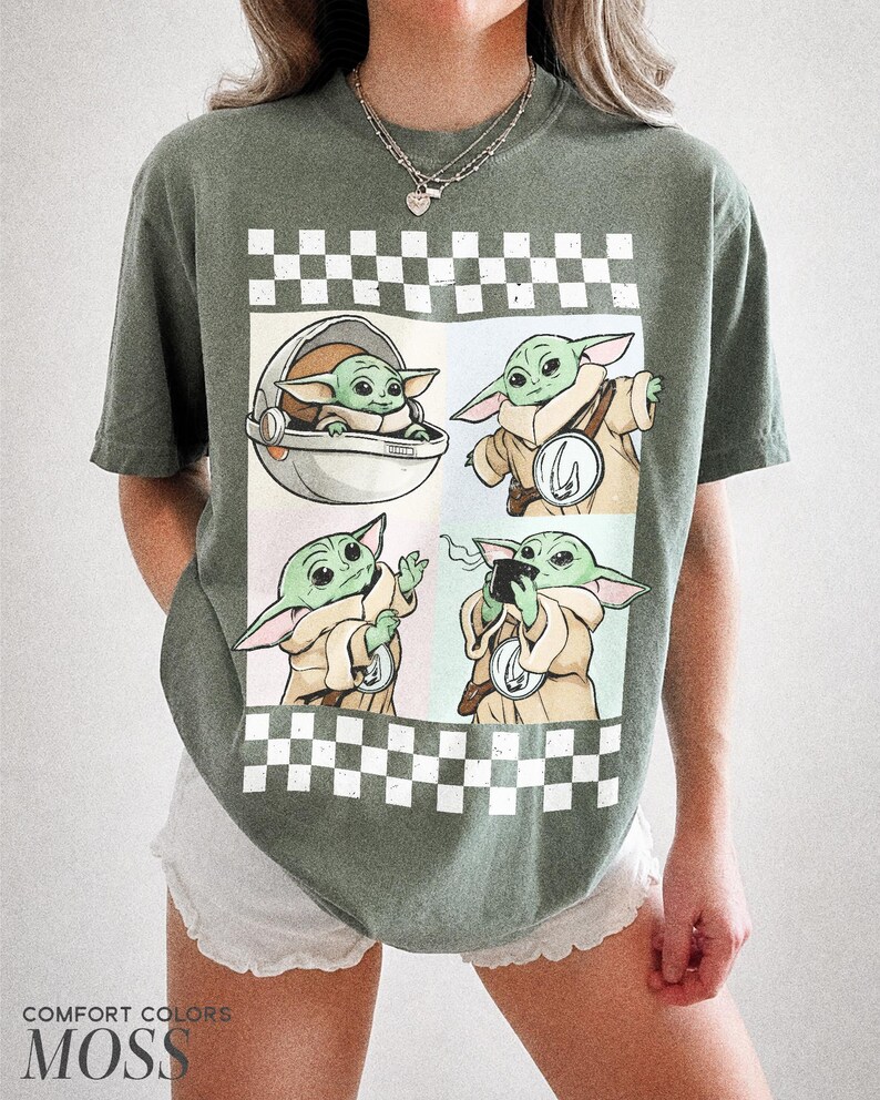 Puede incluir: Camiseta verde Comfort Colors con un dise&ntilde;o de Grogu en cuatro poses diferentes. El dise&ntilde;o est&aacute; sobre un fondo a cuadros blanco y negro. El texto "COMFORT COLORS MOSS" est&aacute; impreso en la parte inferior.