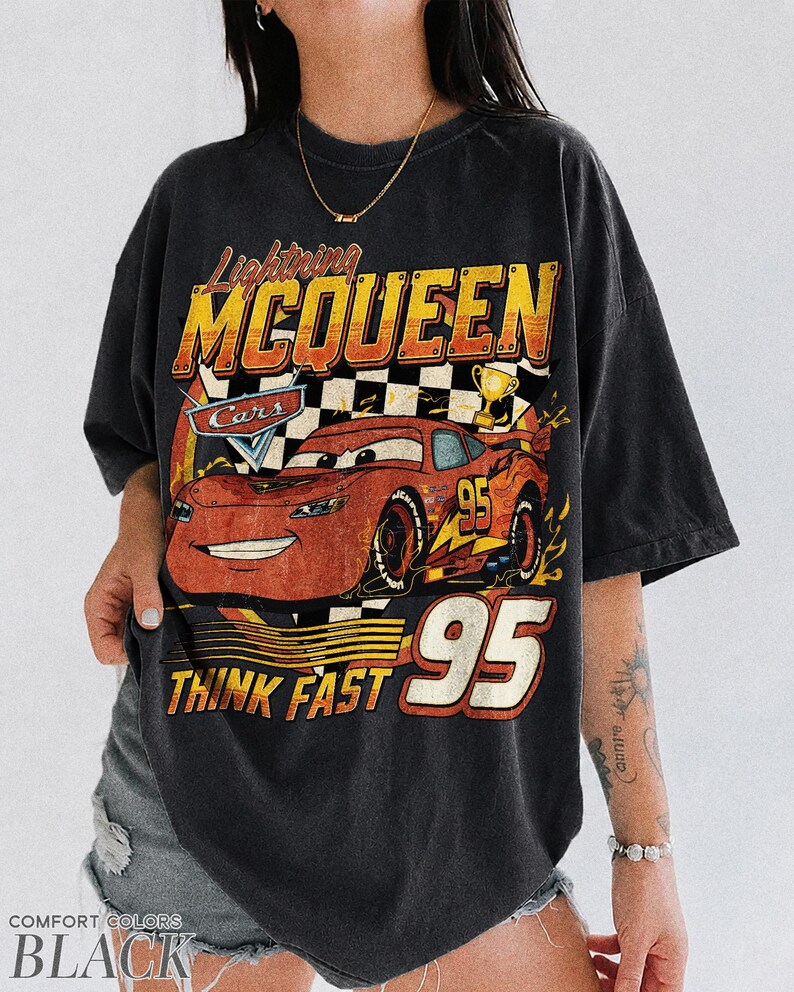 K&ouml;nnte beinhalten: Schwarzes T-Shirt mit Lightning McQueen aus dem Film Cars. Das Design enth&auml;lt die Texte "Lightning McQueen", "Cars", "95" und "Think Fast". Das T-Shirt hat einen Vintage-Look.