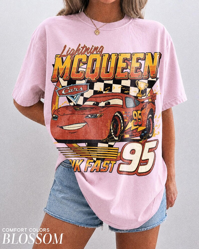 K&ouml;nnte beinhalten: Hellrosa T-Shirt mit einem Lightning McQueen-Motiv aus dem Film Cars. Das Design enth&auml;lt den Text "Lightning McQueen", "Cars", "95" und "Think Fast". Das Shirt ist ein Comfort Colors Blossom.