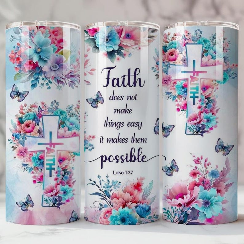 May include: A stainless steel tumbler with a floral design featuring pink, blue, and purple flowers, butterflies, and a cross. The tumbler has the text "Faith does not make things easy it makes them possible" and the Bible verse Luke 1:37.