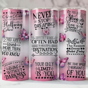 May include: Three pink insulated tumblers with inspirational quotes and butterfly designs. The tumblers feature phrases like "Believe You Can" and "Never Stop Dreaming." Each tumbler is approximately 20 cm tall.