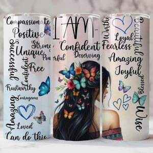 May include: Three white stainless steel tumblers with inspirational text and butterfly designs. One tumbler features the words "Compassionate, Positive, Successful, Unique, Confident, Free, Trustworthy, Courageous, Amazing, Loved, Can do this." Another tumbler has the words "I AM, Confident, Deserving" with a woman's portrait and butterflies. The third tumbler has the words "Worthy, Loyal, Fearless, Amazing, Joyful, Beautiful, Blessed, Wise."