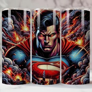 May include: A stainless steel tumbler with a detailed illustration of Superman. The artwork shows Superman with a stern expression, surrounded by fiery explosions and billowing smoke. The design incorporates the iconic "S" shield.
