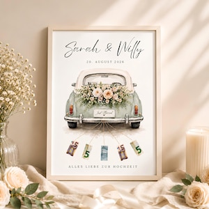 Op de afbeelding: Een ingelijste print met een illustratie van een oldtimer met een bloemstuk op de kofferbak, een Just Married-kentekenplaat en vijf hangende eurobiljetten. De tekst luidt Sarah & Willy, 20. AUGUST 2026 en ALLES LIEBE ZUR HOCHZEIT.