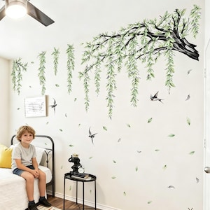 May include: A wall decal set featuring a large, dark-colored tree branch with long, cascading green willow leaves. The design includes several small, flying bird silhouettes and scattered individual leaves, creating a nature-inspired scene.