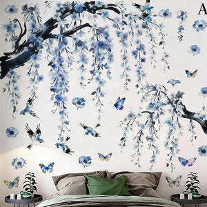 May include: Wall decal featuring a watercolor design of blue flowers, branches, birds, and butterflies. The design includes a large tree branch with hanging flowers, scattered birds, and butterflies in various sizes and colors. The background is white.