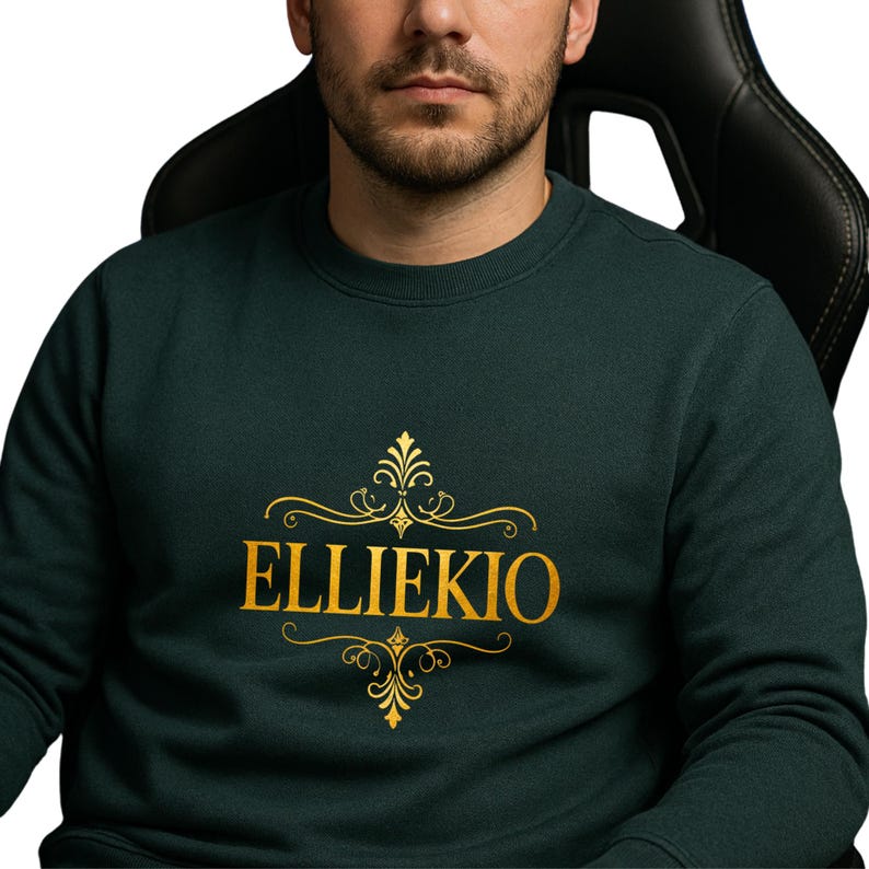 May include: A dark forest green crewneck sweatshirt featuring the text ELLIEKIO printed in a bold gold font. The text is centered on the chest and is framed by decorative gold filigree flourishes above and below the lettering.