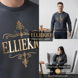 May include: A dark gray crewneck sweatshirt featuring the gold text ELLIEKIO centered on the chest. The text is surrounded by an ornate, symmetrical gold filigree design. The sweatshirt has long sleeves and a ribbed collar, cuffs, and hem.