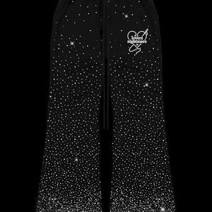 K&ouml;nnte beinhalten: Schwarze Jogginghose mit funkelndem Strass-Design. Die Hose hat einen Kordelzug in der Taille und eine wei&szlig;e Grafik mit der Aufschrift "lovers nightmare" mit Herz und Stern.