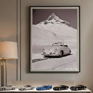 Puede incluir: Un salón moderno con una fotografía en blanco y negro enmarcada de un coche descapotable clásico en una carretera de montaña nevada. Debajo de la fotografía, un mueble blanco y gris exhibe cinco coches de juguete en miniatura de varios colores. Una lámpara de pie y una mesa auxiliar completan la escena.