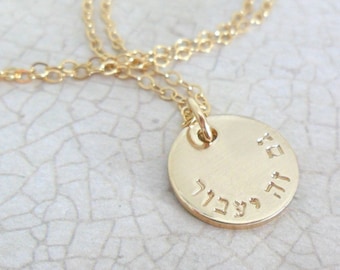 May include: Gold necklace with a round pendant inscribed with Hebrew text. The pendant is about 1 inch in diameter.
