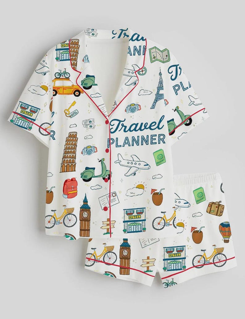 Puede incluir: Conjunto de pijama blanco con tem&aacute;tica de viajes. La camiseta de manga corta y los pantalones cortos presentan un patr&oacute;n repetido de iconos de viaje, incluyendo bicicletas, scooters y monumentos. La parte superior tiene ribetes rojos y la frase "Travel Planner".