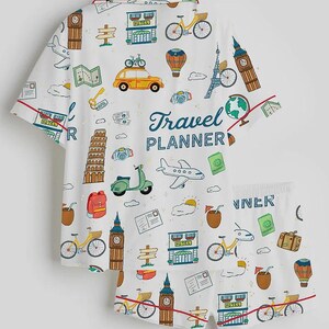 Puede incluir: Conjunto de pijama blanco con estampado de tem&aacute;tica de viajes. La camiseta de manga corta y los pantalones cortos presentan ilustraciones de monumentos, veh&iacute;culos e iconos de viaje. Las palabras "Travel Planner" est&aacute;n impresas en la parte superior.