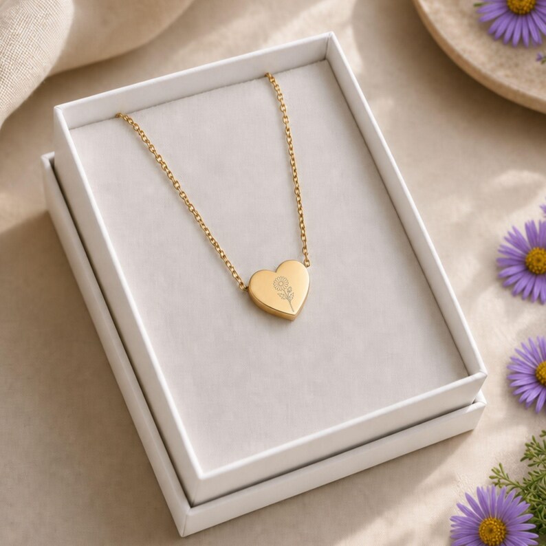Pu&ograve; includere: Una collana con ciondolo a forma di cuore color oro caratterizzata da un delicato disegno di girasole inciso sulla parte anteriore. La collana &egrave; presentata all'interno di una scatola regalo rettangolare bianca con rivestimento interno liscio.