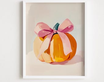 Puede incluir: Una impresión artística enmarcada que presenta una vibrante calabaza naranja con un lazo rosa. La calabaza tiene un tallo verde y está pintada con pinceladas amplias. La obra de arte se encuentra sobre un fondo suave y neutro.