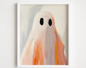 May include: A framed art print depicting a ghost with a white body and black oval eyes. The ghost is painted with strokes of orange and peach, creating a textured effect. The artwork is set against a light grey background.