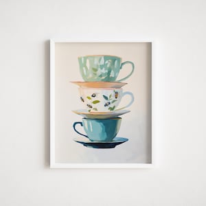 May include: A framed print showing a stack of four teacups. The top cup is mint green with white brushstrokes. The second cup is white with bee and floral designs. The bottom cup is teal blue.