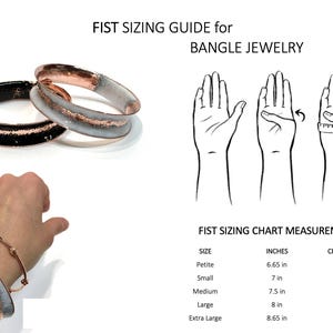 May include: Image shows a fist sizing guide for bangle jewelry. The guide includes a chart with measurements in inches and centimeters. The image also features two bangles, one black and one white with copper accents.