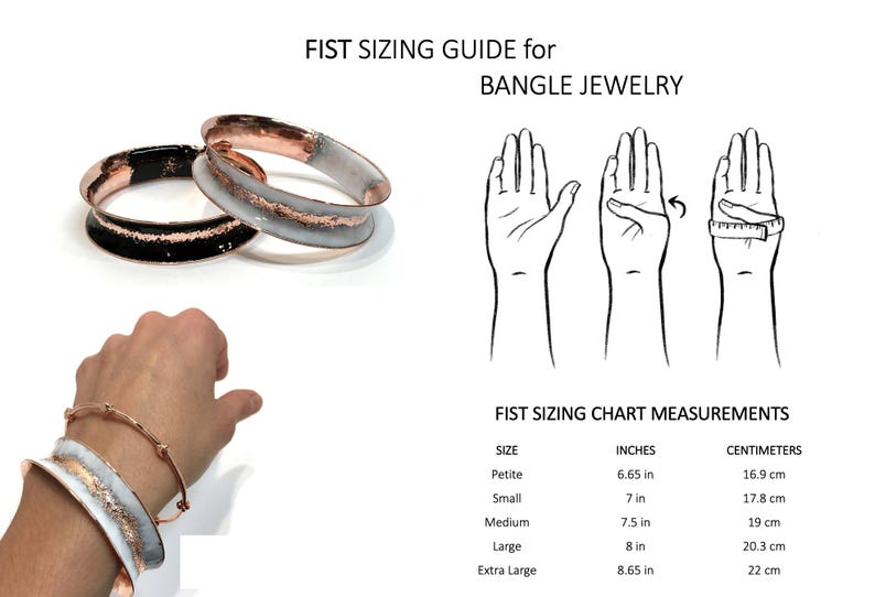 May include: Image shows a fist sizing guide for bangle jewelry. The guide includes a chart with measurements in inches and centimeters. The image also features two bangles, one black and one white with copper accents.