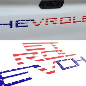 May include: A set of individual adhesive letters spelling out CHEVROLET, designed to fit into the tailgate lettering of a truck. The letters feature a red and white horizontal stripe pattern and a blue field with white stars, mimicking the American flag.