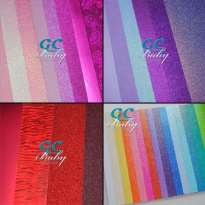Op de afbeelding: Een assortiment glitterpapier in verschillende kleuren, waaronder roze, paars, rood, blauw en groen. Het papier is gerangschikt in rijen en kolommen, en elk vel heeft een ander glitterpatroon. Het papier is gelabeld met "GC Baby" en is waarschijnlijk bedoeld voor knutselen of scrapbooking.