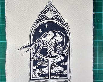 May include: A black and white linocut print of a peregrine falcon inside a window frame. The sun and stars are above the bird. The text "THE PEREGRINE" is below the window.