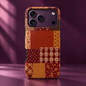 Könnte beinhalten: Eine Smartphone-Hülle mit einem Patchwork-Design aus verschiedenen herbstlichen Mustern, darunter Kürbisse, Blätter, Sterne, Karos und Blumenmotive in Orange-, Braun- und Dunkelrottönen. Das Gehäuse hat einen dunkelvioletten Kamerabereich.