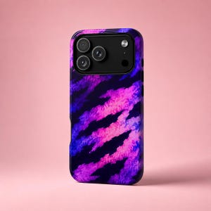 Pode incluir: Uma capa de smartphone com um padrão abstrato e vibrante de listras diagonais em tons de rosa neon, roxo profundo e azul escuro. A capa tem um módulo de câmera preto no topo, revelando três lentes circulares e um flash.