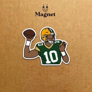 May include: A sticker featuring a cartoon illustration of an American football player in a green and yellow uniform, throwing a brown football. The player wears the number 10. The word "Magnet" is above the image.