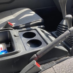 Może przedstawiać: Zestaw trzech ceramicznych kubków z kremowym, nakrapianym szkliwem. Każdy kubek zdobi ręcznie malowany kwiatowy wzór w odcieniach niebieskiego, zielonego i żółtego. Kubki mają prosty, zaokrąglony kształt i wygodny uchwyt.